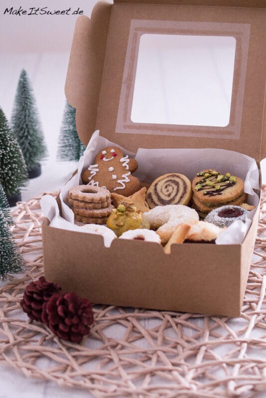 Viele Plätzchen verpacken in einer Papierbox mit Butterbrotpapier