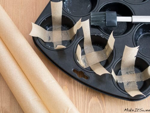 Mit Backpapier ausgelegte Muffinform, bereit zum Backen von Muffins ohne Förmchen.