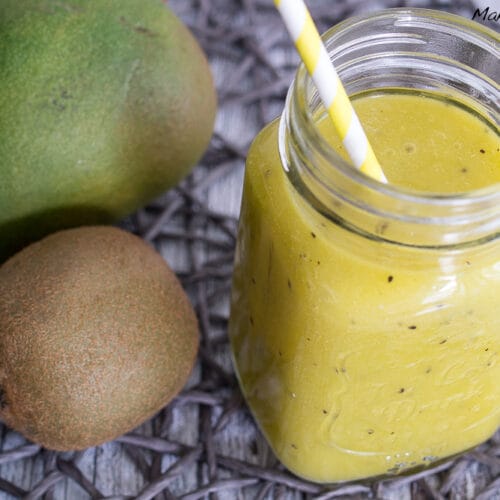 Kiwi Smoothie mit Mango, Orangensaft und Limettensaft 3 Gelber Kiwi- und Mango-Smoothie in einem Einmachglas mit Strohhalm, dazu frische Pomelo und Kiwi.