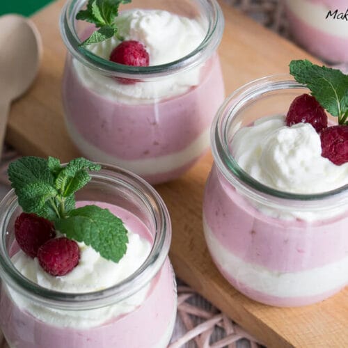 Himbeerquark mit Sahne - Schichtdessert 3 Drei Gläser Himbeermousse mit Schlagsahne, frischen Himbeeren und Minzblättern.