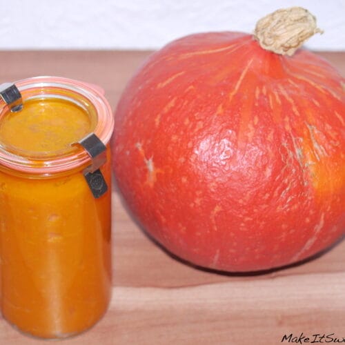 Kürbispüree: Rezept, Verwendung und Einkochen 3 Glasgefäß mit Kürbispüree und ganzem Hokaido-Kürbis auf Holzunterlage.