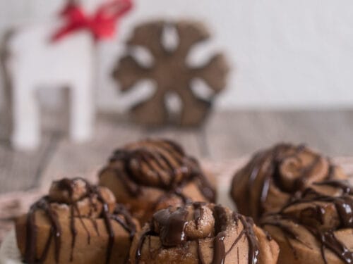 Lebkuchen-Schnecken mit Schokolade beträufelt auf einem Teller.