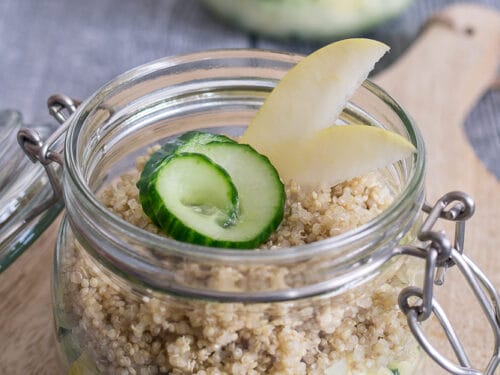 Zwei Quinoa-Salate im Glas mit Gurke und frischen Apfelspalten.