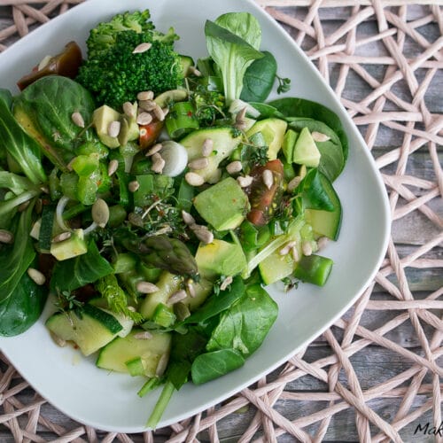 Gemischter grüner Salat mit Echt & Gut von EDEKA {Werbung} 4 Grüner Salat mit Spinat, Gurken, Brokkoli, Paprika, Tomaten, Samen und Kräutern auf einem Teller.