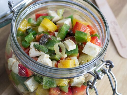 Paprikasalat mit Feta und Frühlingszwiebeln in einem Glas zum Mitnehmen.