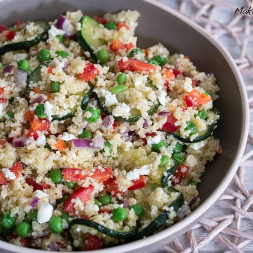 Couscous Salat mit Zucchini, Feta, Paprika und Erbsen 3 Schüssel mit Couscous-Salat mit Zucchini, Erbsen, roter Paprika, roten Zwiebeln und zerbröckeltem Feta.