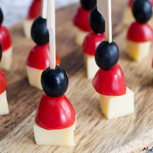 Deutschland Fingerfood zur WM oder EM 3 Spieße mit Käsewürfeln, Kirschtomatenhälften und schwarzen Oliven auf einem Holzbrett angeordnet in Farben der deutschen Flagge.
