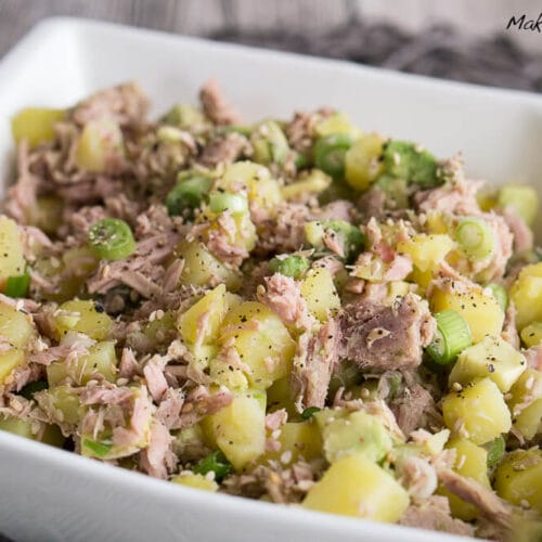 Kartoffel-Thunfisch-Salat mit Avocado 3 Thunfischsalat mit gewürfelter Kartoffel, Avocado, Frühlingszwiebeln und schwarzem Pfeffer, serviert in einer weißen Schale.