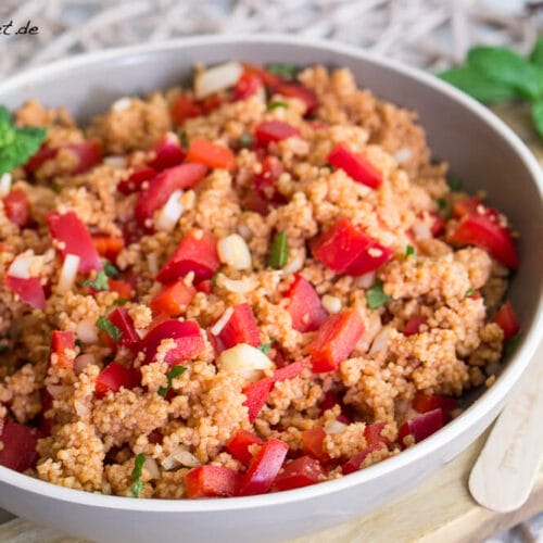 Couscous Salat mit Paprika und Minze 3 Couscous-Salat mit Paprika, Zwiebeln und Minze in einer Schüssel mit rotem Dressing.