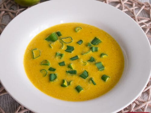 Mango-Karotten-Suppe mit Frühlingszwiebeln, serviert mit Chili, Ingwer, Limette und Mango.