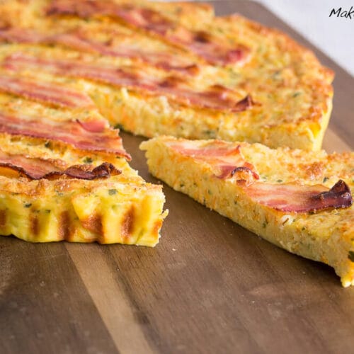 Pfannkuchen-Tarte mit Bacon, Kartoffeln und Karotten 2 Eine Pfannkuchentarte mit Bacon, bei der ein Stück fehlt, um die schmackhafte Füllung und Kruste zu zeigen.