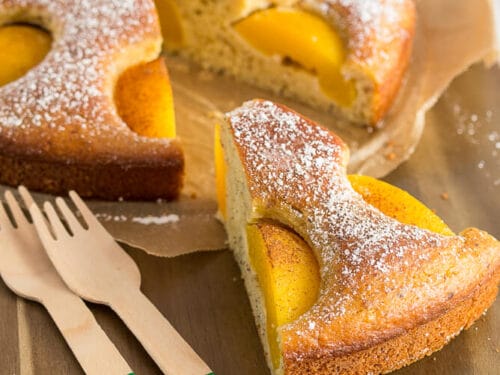 Ein Pfirsichkuchen mit Skyr, aus dem ein Stück herausgeschnitten wurde.