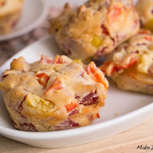 Herzhafte Muffins mit Paprika und Salami auf einem weißen Teller.