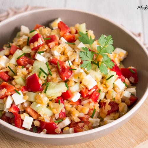 Linsensalat mit Paprika, Gurke und Feta 3 Schüssel mit Linsensalat mit geschnittener Paprika, Gurke, Feta und frischen Kräutern.