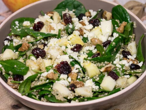 Eine Schüssel Wintersalat mit Spinat, Quinoa, Apfel, Feta, Walnuss und Cranberries.