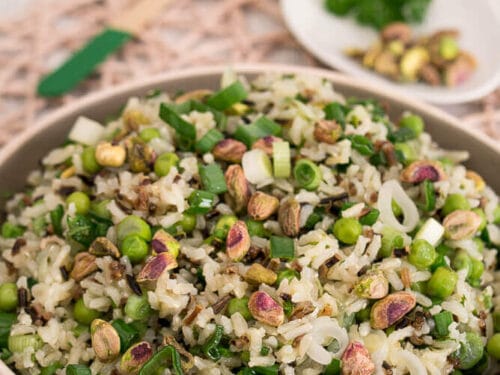 Wildreissalat in einer Schüssel mit Pistazien, grünen Erbsen und Frühlingszwiebeln.