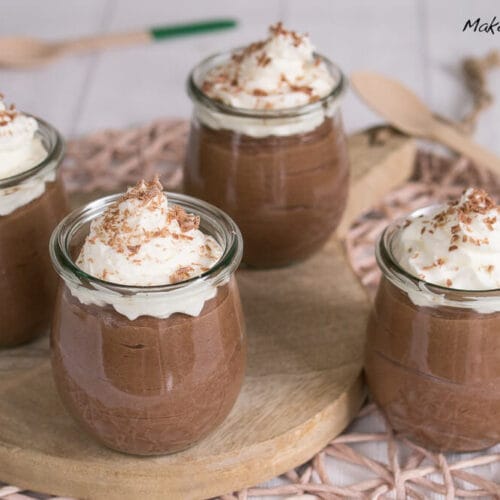 Vier Gläser Nutella-Schokoladenmousse mit Schlagsahne und Schokoladenraspeln.