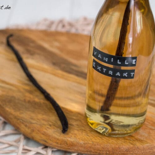 Vanilleextrakt selber machen 3 Eine Flasche mit der Aufschrift "Vanille Extrakt" und eine Vanilleschote auf einem hölzernen Schneidebrett.