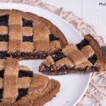 Auf einem Teller liegt eine Linzertorte mit Gittermuster.