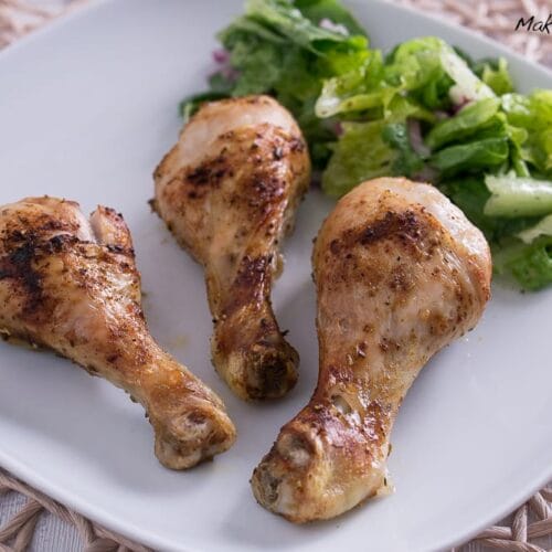 Hähnchen-Unterkeulen in der Heißluftfritteuse 3 Drei frittierte Hähnchen-Unterkeulen aus der Ninja Speedi Heissluftfritteuse mit frischem grünen Salat auf einem weißen Teller.