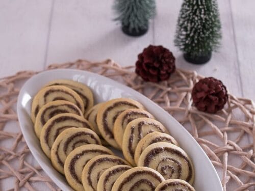 Teller mit Zimtschnecken-Plätzchen mit Zimt, Zucker und Kakaopulver.