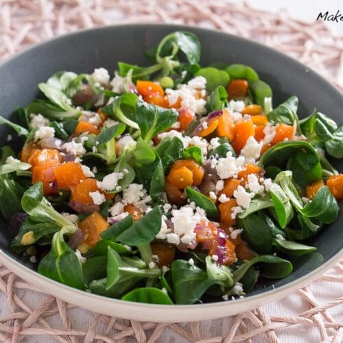Feldsalat mit Möhren und Feta Wintersalat 3 Wintersalat mit Feldsalat, gebackenen Möhren, roten Zwiebelscheiben und zerbröckeltem Feta in einer grauen Schale.