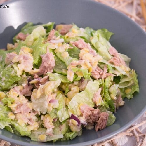 Thunfischsalat mit Kopfsalat, Linsen, roten Zwiebeln und cremigem Dressing in einer Schüssel.
