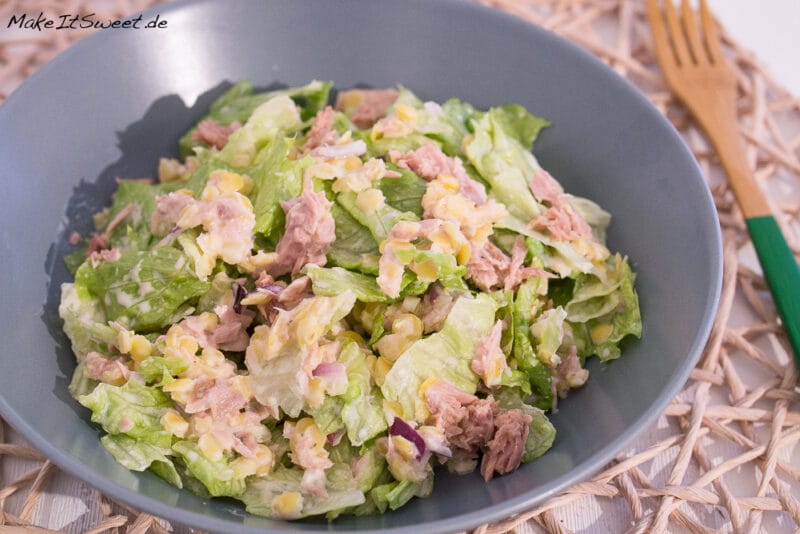 Eine Schüssel mit einem Linsensalat mit Thunfisch, grünem Salat und einem Joghurt-Dressing