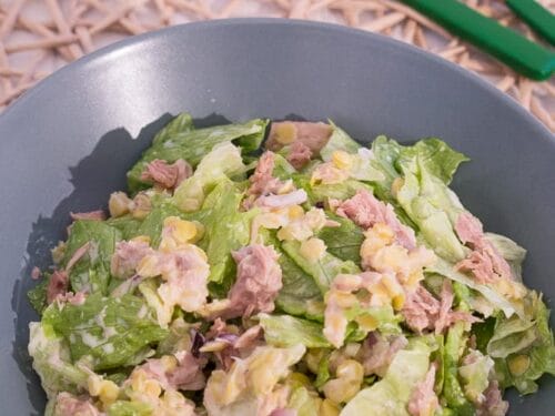 Eine Schüssel Thunfischsalat mit Salat, Linsen und Dressing. Alles gut vermischt.