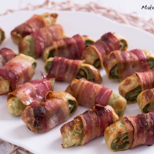 Mit Bacon umhüllte Maultaschen aus dem Airfryer, die auf einem weißen Teller angerichtet sind.