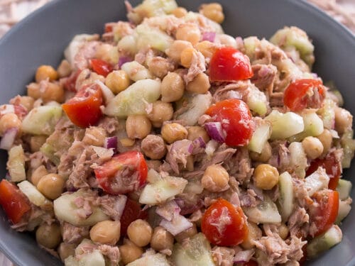 Schale mit Thunfischsalat mit Kichererbsen, Kirschtomaten, Gurken und roten Zwiebeln.