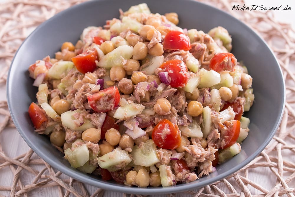 Schale mit Thunfischsalat mit Kichererbsen, Kirschtomaten, Gurken und roten Zwiebeln.