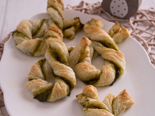 Herzhafte Blätterteig-Hasen mit grüner Pesto-Füllung auf einem weißen Teller.