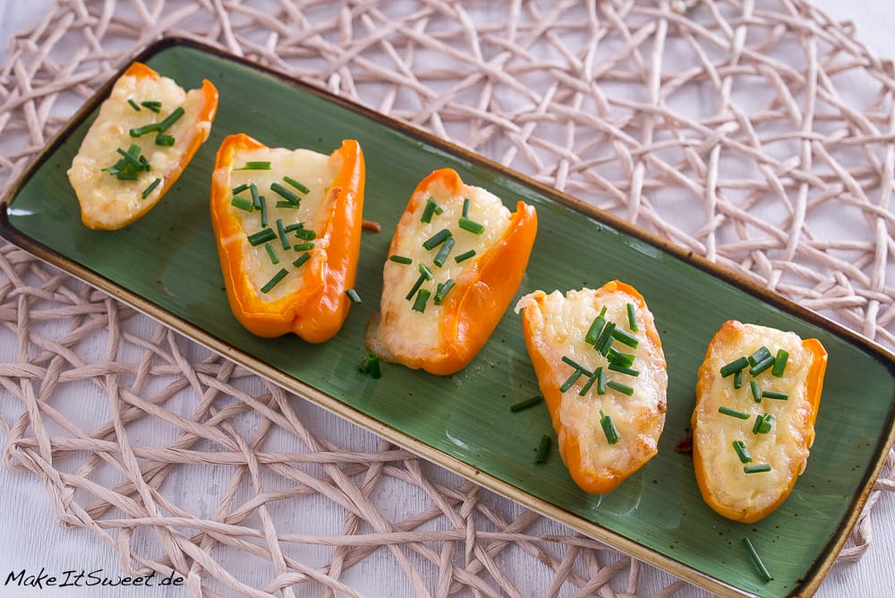 Gebackene Mini-Paprikas, gefüllt mit Feta und Ei, bestreut mit Schnittlauch.