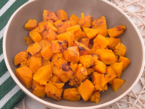 Schüssel mit gerösteten orangefarbenen Kürbis aus dem Airfryer.