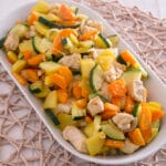 Hähnchenbrust mit Gemüse aus der Heißluftfritteuse Gebratenes Hühnerfleisch, Zucchini, Karotten und Kartoffeln auf einem weißen Teller.