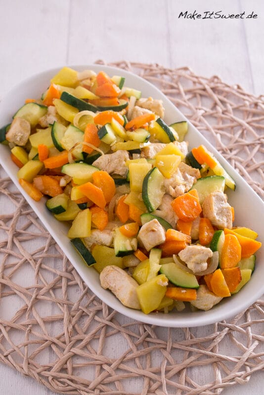 Hähnchenbrust mit Gemüse aus der Heißluftfritteuse 2 Gebratenes Hühnerfleisch, Zucchini, Karotten und Kartoffeln auf einem weißen Teller.