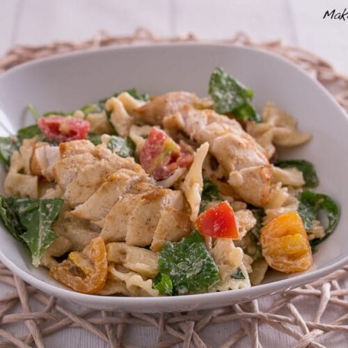 Nudelsalat mit Rucola, Hähnchen und Tomate + French-Dressing 3 Nudelsalat mit Rucola in einer Schüssel mit gegrilltem Hähnchen, Rucola und Kirschtomaten.