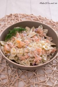 Nudelsalat mit Räucherlachs und Joghurt-Dill-Dressing 5 Nudeln mit Joghurt Soße, Räucherlachs, Dill und Zwiebeln in einer Schüssel.